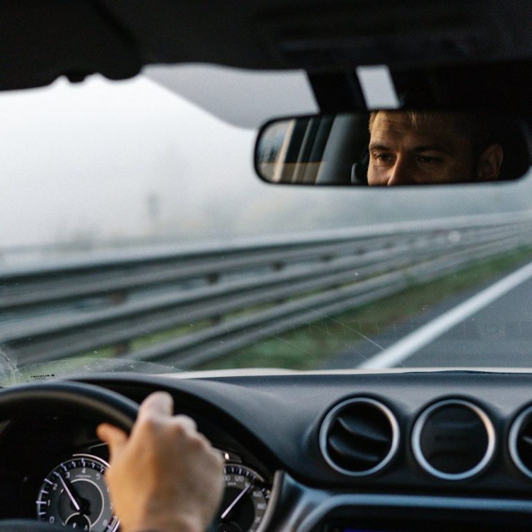 Volvo V60 Classe-Affaires VTC Haute-Savoie Conducteur au volant, regardant dans le rétroviseur sur une route brumeuse.