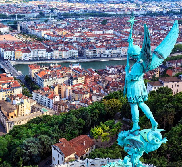 Classe-Affaires VTC Chamonix Mont-Blanc Lyon Statue d'un ange au sommet d'une colline surplombant la ville de Lyon.