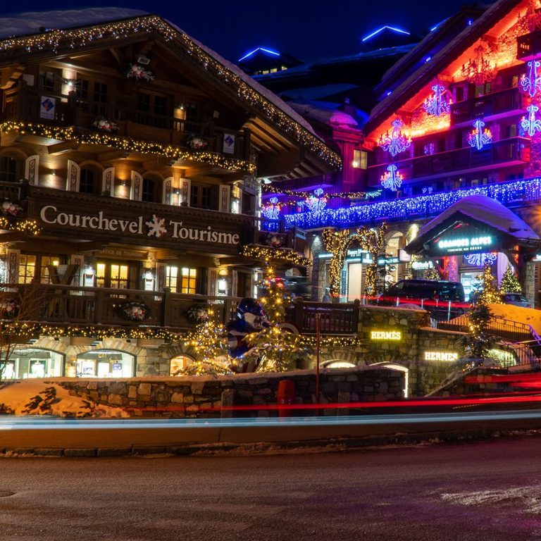 Classe-Affaires VTC Chamonix Mont-Blanc Gstaad Vue panoramique d'une vallée verdoyante de Gstaad avec un grand hôtel et des montagnes en arrière-plan.