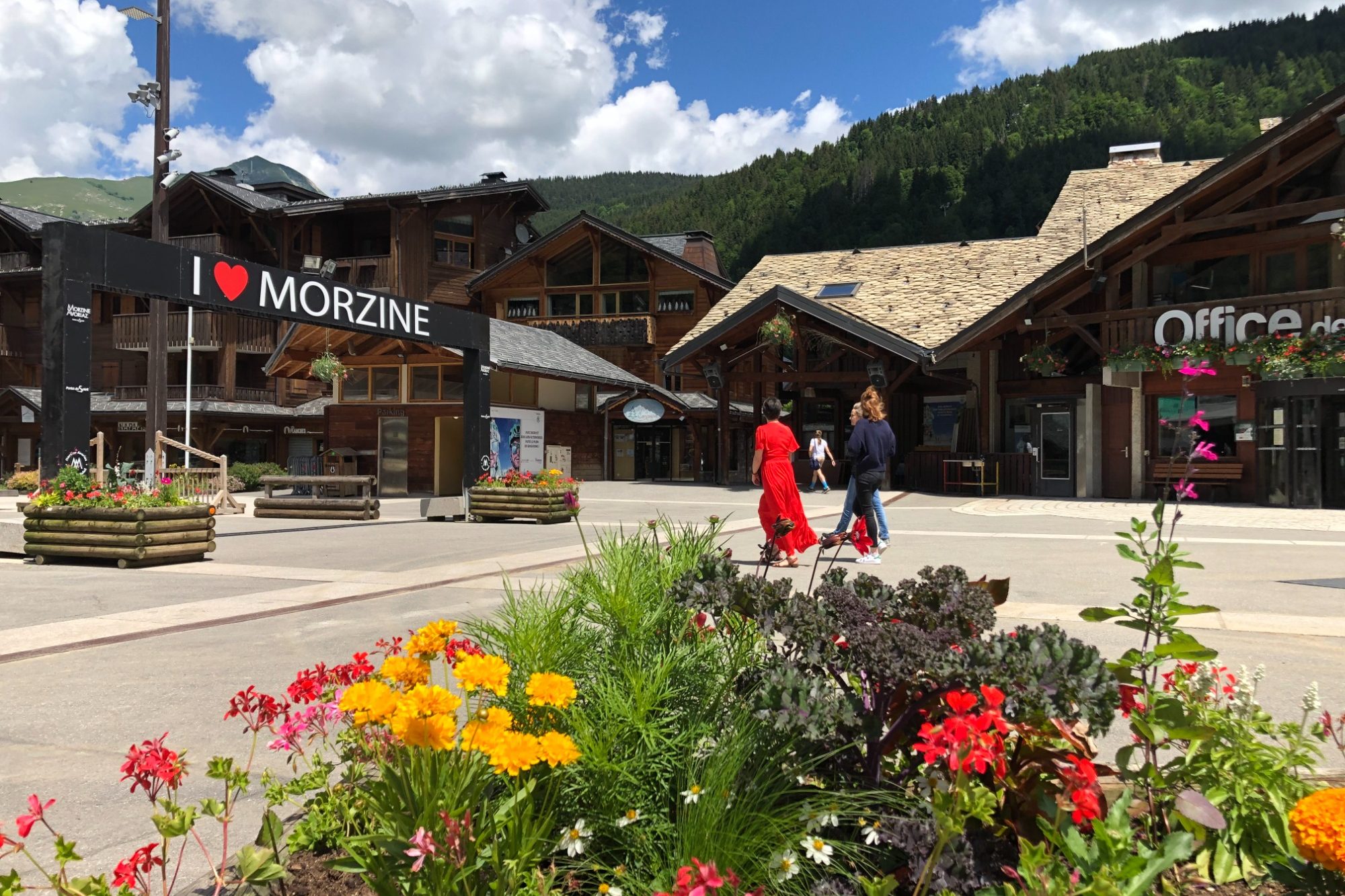 Classe-Affaires VTC Morzine Les Gets Avoriaz Rue animée de Morzine avec des fleurs colorées et des bâtiments montagnards.